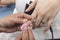 A manicurist uses a cotton bud soaked in acetone to remove leftover polish from the index fingernail of a customer.