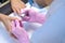 Manicurist woman removes shellac polish using manicure machine, hands closeup.