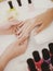 Manicurist Works with Clients in Beauty Salon.