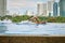 Manila, Philippines - Feb 02, 2020. A man swims a front crawl in a pool on the roof of a luxury hotel. View of the city of Manila