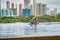 Manila, Philippines - Feb 02, 2020. A man swims a front crawl in a pool on the roof of a luxury hotel. View of the city of Manila