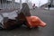 A mannequin body in a black plastic bag lies on the road