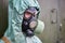 Mannequin dressed in green rubber chemical protection suit and black gas mask, close-up