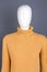 Mannequin dressed in women yellow sweater.