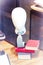 Mannequin head on a stand with a tie and books in a shop window