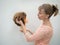 A mannequin head for teaching hairdressing in hands on a light background. Beauty concept.