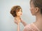 A mannequin head for teaching hairdressing in hands on a light background. Beauty concept.