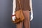 Mannequin with leather brown handbag.