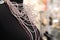 Mannequin with a sparkling bead necklace on the unfocused background of a jewelry store