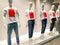 Mannequins wearing white tshirts with red text Sale in window clothing store.