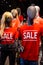 Mannequins in a window of a clothing store in T-Shirts With Signs Advertising Sale