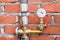 Manometer with a valve on a pipe with insulation against the background of a brick wall of a heating unit at an industrial