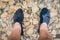 Mans feet in the water of a river with rocks in the background