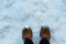 Mans feet in winter boots on the fresh snow