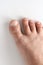 Mans foot on a white background. The leg of a white man. Big toe closeup