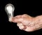 Mans hand holding an illuminated halogen lightbulb