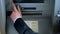 Mans hand pressing button on display screen of ATM machine, bank account access