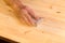 Mans hand on sanding block on pine wood