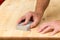 Mans hand on sanding block on pine wood