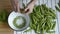 Mans hand shelling fresh ripe green peas bean