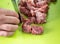 Mans hands cut raw meat with the knife in the kitchen closeup. Preparation of minced meat from fresh pork through a