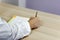 The mans hands on white medical outfit write with roller pen on the paper on wooden table.