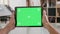 Mans point of view holding a tablet with green screen on