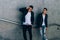 mans posing near railing. Handsome young mans in stylish black clothes and white shoes posing near a railing. friendship