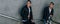 mans posing near railing. Handsome young mans in stylish black clothes and white shoes posing near a railing. friendship