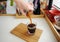 Manual brewing still life. Pouring filter coffee from decanter into crystal glass. Bamboo board