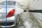 Manual car wash. Washing luxury vehicle with high pressure water pump. Automobile cleaning self service. water wash foam off car.