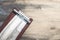 Manual carpentry holder for sandpaper lies on the sanding surface of an old wooden black table. Home repairs