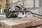 manual circular saw is on a wooden board in house under construction of foam block