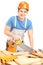 Manual worker with helmet cutting wooden batten with a saw