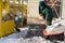 A manual worker scoops snow from the pavement and shovels it onto a pile next to it