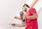 Manual worker with wall plastering tools inside a house