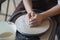 The manufacture of ceramics. Woman prepare clay for work on pottery wheel. Close up view of hands.