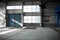 Manufacturing factory. Empty hangar building. Blue toned background. The production room with large windows and metal structures