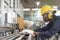 Manufacturing worker. Professional African-American worker uesing laptop controlling the work. Cheerful Factory Worker Posing