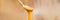 Manuka honey dripping from golden spoon healthy natural superfood on wooden panoramic banner background