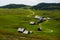 many alpine huts with dirt roads and cows in a green nature landscape