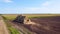 Many bales of rolls of dry straw after wheat harvest on field. Bales form rolls