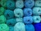 Many balls of wool yarn in natural shades of green and blue for knitting  crocheting