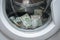 Many banknotes are inside Washer. A lot of cash dollars is washed in the drum of a washing machine. The concept of not legal money