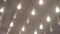 Many beautiful bright light bulbs decorate the ceiling of a large room.