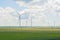 Many big and high windmills at sunny day on the green field. Alternative energy generators. Wind energy. Ecology, save, energy