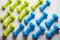 many blue and green dumbbells on a white background , concept preparing to fitness sports equipment top view mock up