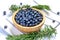Many blueberries in a wooden bowl placed on the fabric