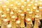 Many bottles of champagne with golden foil top in rows. Party celebration background. Wedding and christmas beverage