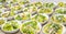 Many bowls of fresh green salad on a table
